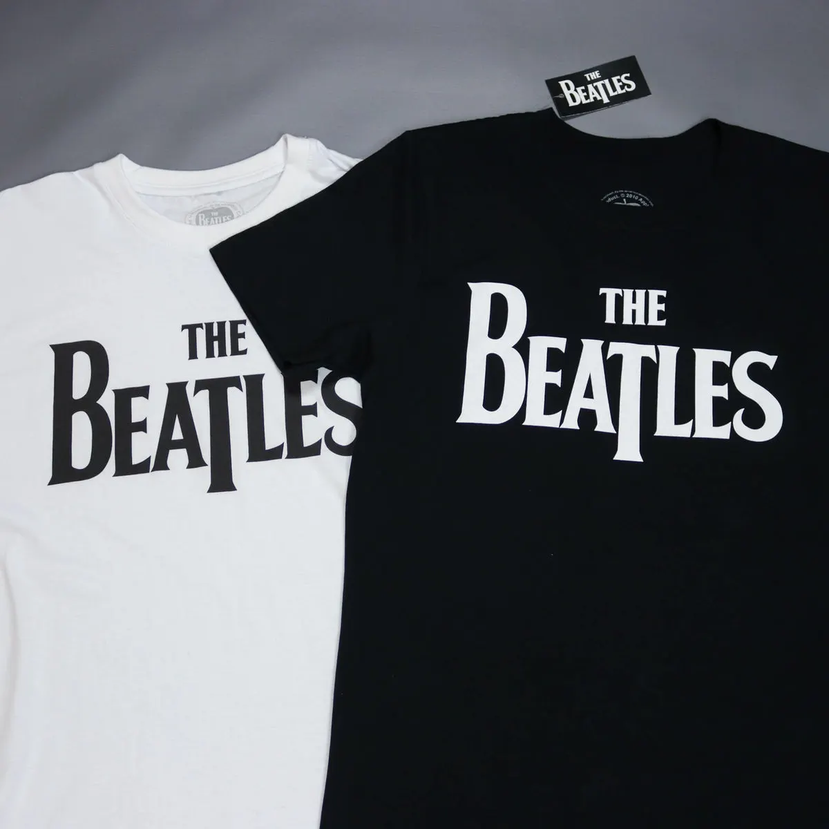 White and black The Beatles drop T logo t-shirts side by side