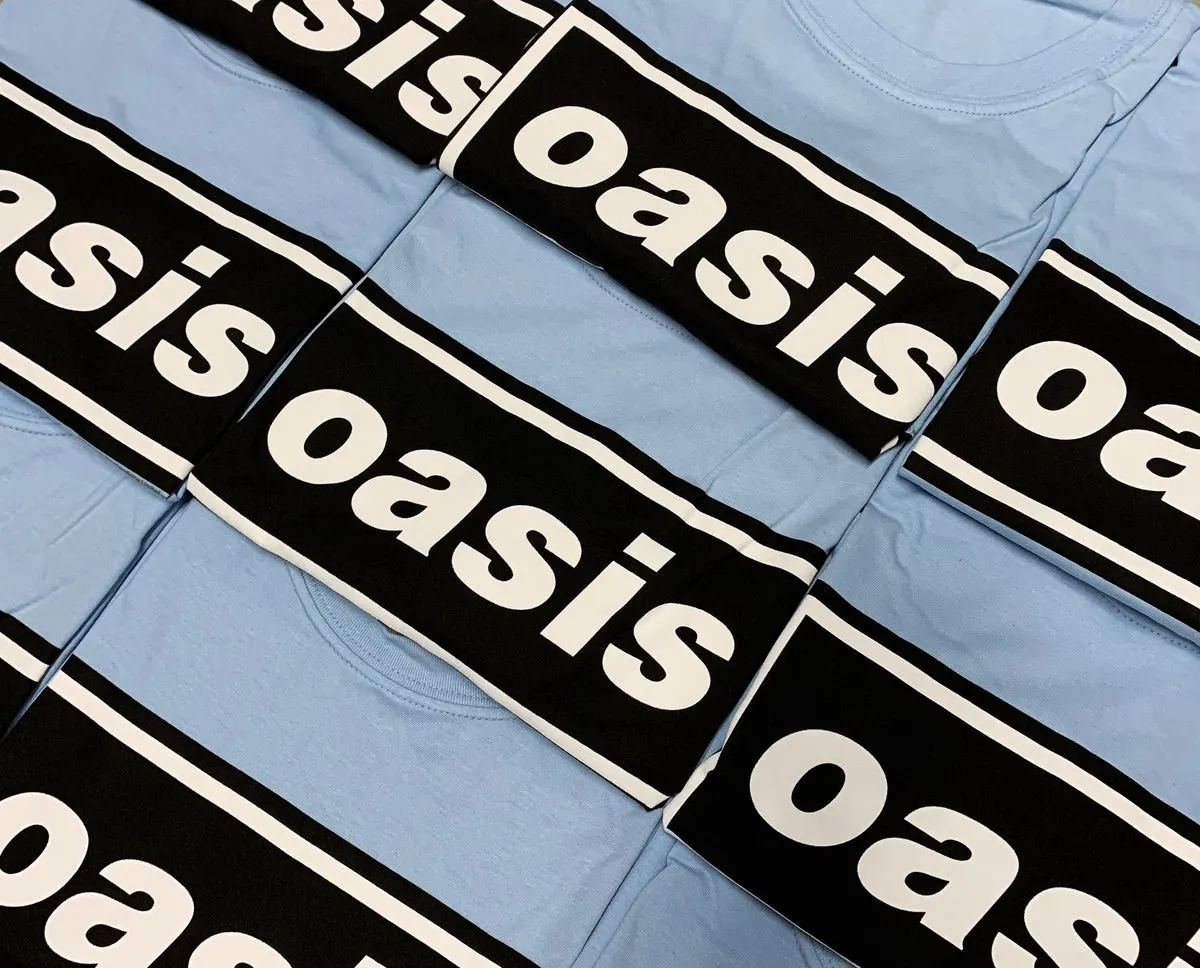Folded light blue and black Oasis logo t-shirts in a row
